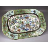 Small ceramic plate of oblong form with floral and foliate hand painted decoration on green