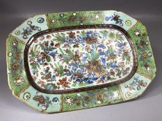 Small ceramic plate of oblong form with floral and foliate hand painted decoration on green