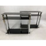 Pair of modern black glass and chrome shelving units, each approx 90cm x 30cm x 76cm tall