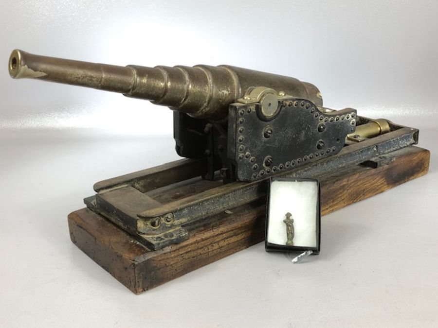 Reproduction Black Powder Cannon with tapering barrel on wooden base with firing pin in the shape of