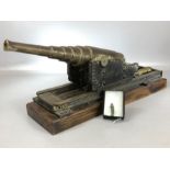 Reproduction Black Powder Cannon with tapering barrel on wooden base with firing pin in the shape of