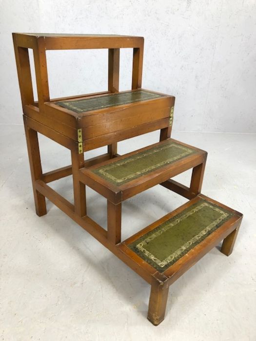 Metamorphic library table with green leather inserts that transforms into library steps