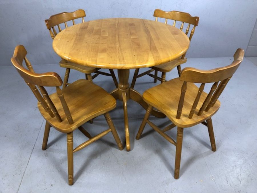 Circular pine table on pedestal base with four pine spindle back chairs, diameter approx 90cm