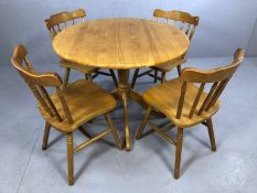 Circular pine table on pedestal base with four pine spindle back chairs, diameter approx 90cm