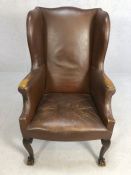 Leather wing back fireside chair on ball and claw feet