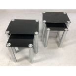 Pair of modern black glass and chrome nests of two tables, largest of each approx 45cm x 35cm x 50cm