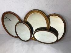 Collection of five oval gilt and wooden mirrors, the largest approx 86cm x 66cm