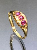 18ct Gold ring set with three Rubies and flanked by rows of Diamonds, fully hallmarked size 'P' (