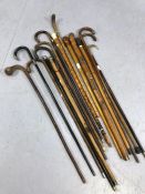 Large collection of walking canes / sticks, of varying designs and lengths, some with silver tips or