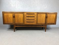 Mid Century red label G-Plan sideboard with cupboards either side and drawers to centre, raised on