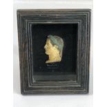 Framed head, of a Roman profile, in relief, painted and wearing laurel leaves. Whilst behind