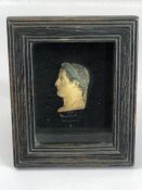 Framed head, of a Roman profile, in relief, painted and wearing laurel leaves. Whilst behind