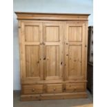 Large pine triple wardrobe with hanging rails and three drawers to base. Approx: 57cms x 205cms x