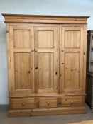 Large pine triple wardrobe with hanging rails and three drawers to base. Approx: 57cms x 205cms x