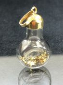 Interesting pendant or charm of a bottle containging Gold flakes with a 14ct Gold lid approx 27mm