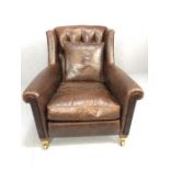 Wing-back armchair by Duresta, covered in brown leather, with buttoned back, rounded arm supports