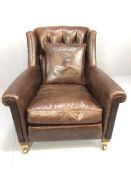 Wing-back armchair by Duresta, covered in brown leather, with buttoned back, rounded arm supports