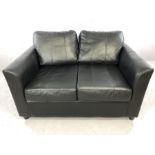 Small black leather two-seater sofa, approx 130cm in length