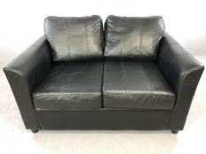 Small black leather two-seater sofa, approx 130cm in length