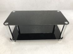 Modern black glass and chrome coffee table / TV unit, approx 100cm x 50cm x 46cm tall