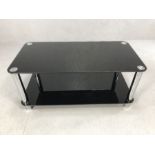 Modern black glass and chrome coffee table / TV unit, approx 100cm x 50cm x 46cm tall