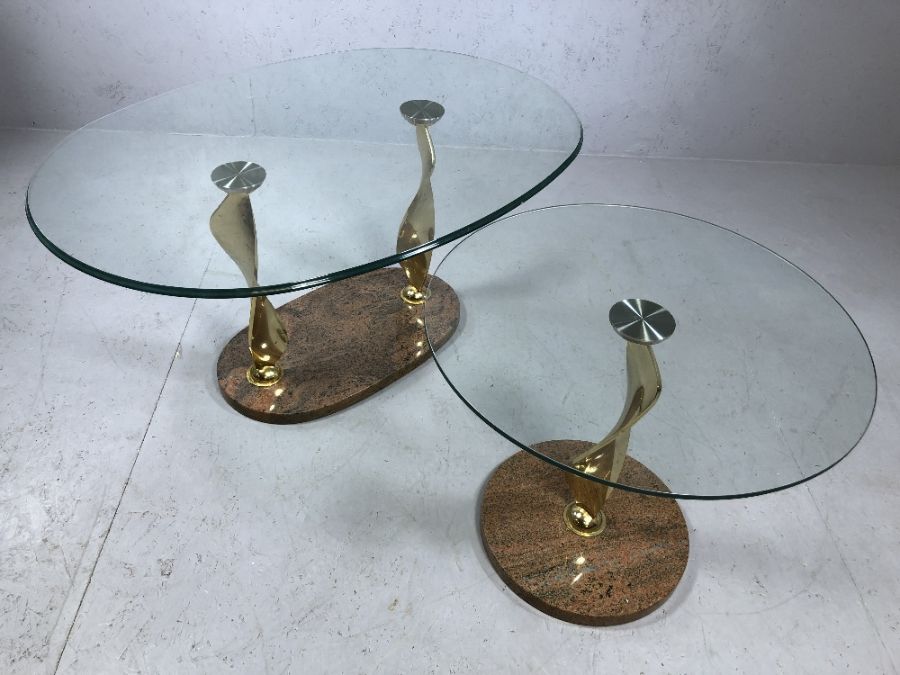 Modern glass oval coffee table on twisted gold coloured legs with marble plinth and matching