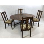 Heavy drop leaf oval dining room table with four carved wooden chairs with tapestry cushions,
