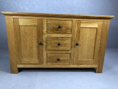 Modern oak sideboard with two cupboards and three drawers, approx 150cm x 49cm x 90cm tall