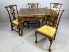 Carved wooden extendable table with bow legs and rose detailing, accompanied by four ornately carved