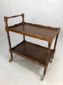 Two tier vintage tea trolley on turned legs and original castors