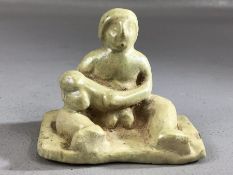 Ceramic figure of a seated man with large phallus, remnants of pale green glaze, approx 7cm wide