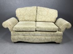 Cream upholstered drop arm two seater sofa on castors