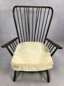 Ercol model 1913 armchair with large wingback spindle back and shaped armrests, raised on short