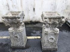 Two large stone plinths, surmounted by two square garden planters, each approx 93cm in height