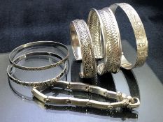 Collection of six silver and silver coloured bangles