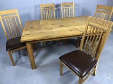 Modern extending dining table on square legs with five slat back padded seat chairs