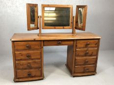 Pine dressing table with nine drawers and a matching triptych mirror over, on castors, approx