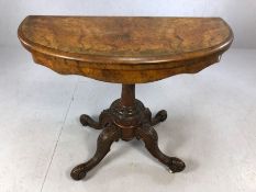 Victorian card table on pedestal base with carved detailing and four carved legs, opens to reveal