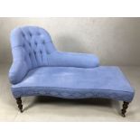 Modern chaise lounge in blue linen, with turned legs on castors, stitching detail and buttons (