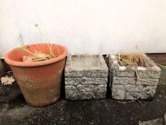 Two square concrete planters and a circular terracotta planter