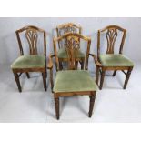 Four shaped wooden dining chairs with padded seats to include one carver