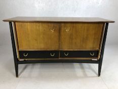 G-Plan sideboard on ebonised frame with black drawer fronts, gold fittings and two cupboards with