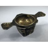 Silver hallmarked tea strainer in square pot hallmarked for Birmingham by maker Barker Brothers