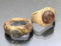 Artefacts: two rings, possibly Roman, the first with applied resin centre depicting the face of a
