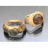 Artefacts: two rings, possibly Roman, the first with applied resin centre depicting the face of a