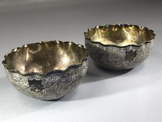 Pair of Indian Silver heavily embossed Silver bowls with crimped edges and both with unmarked shield