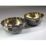 Pair of Indian Silver heavily embossed Silver bowls with crimped edges and both with unmarked shield