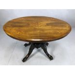 Victorian oval tilt top table with decorative inlay on carved legs with original castors, approx