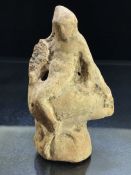 Terracotta pipe clay figurine, possibly Roman, depicting a youth seated backwards, on the back of