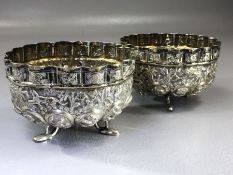 Pair of Indian Silver repousse bowls on tripod fish shaped feet and depicting Elephants, Tigers,